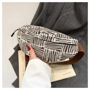 Detail of woven canvas chest bag featuring brown geometric stripes and textured strap