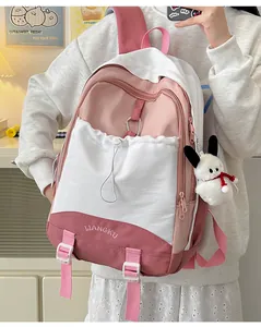 Detail eines rosa-weißen Schulrucksacks mit Hasen-Plüschanhänger und Stickerei