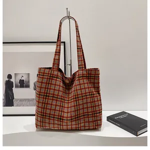 Detail of vintage plaid tote bag featuring a wooden button closure and thick woven texture