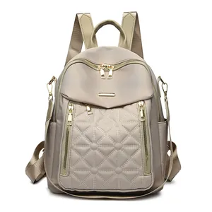 Zaino da donna in nylon trapuntato color oro champagne con cerniere in metallo