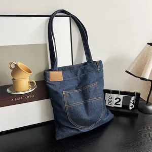 Bolso tote de mezclilla azul oscuro con bolsillo frontal grande y costuras en contraste