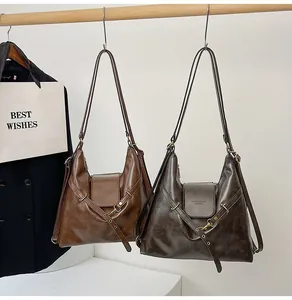 Detalle de bolsos hobo vintage grandes en marrón y oliva con correas ajustables