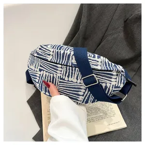 Detail of blue and white geometric canvas chest bag with adjustable navy nylon strap