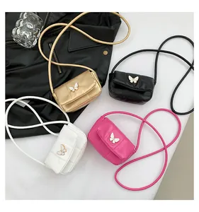 Flat lay of mini quilted crossbody bags in four colors with butterfly ornaments
