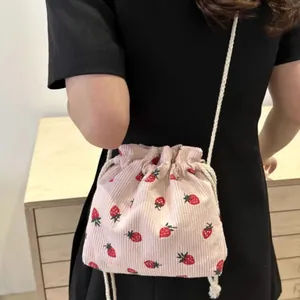 Pink corduroy bucket bag with strawberry print and white drawstring strap for women