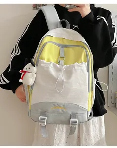Details des Farbblock-Rucksacks mit gelber Stickerei und weißem Plüschtier-Anhänger