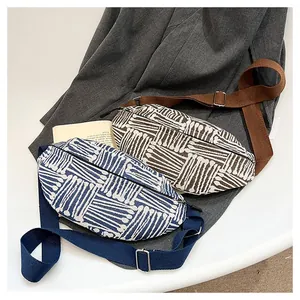 Close-up of ethnic style canvas chest bags with geometric weave and adjustable straps