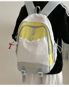 Detail des dreifarbigen Patchwork-Schulrucksacks mit LIANGKU-Stickerei und Plüschwelpen-Anhänger