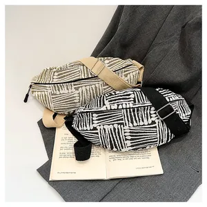 Detailed macro view of two canvas fanny packs featuring ethnic striped patterns on a blazer.