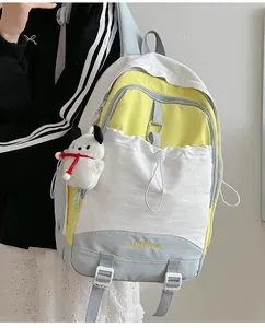 Details des mehrfarbigen Schulrucksacks mit gelben Akzenten und niedlichem Plüschanhänger