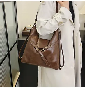 Detalle de un gran bolso de hombro de cuero marrón con textura vintage y hebilla de metal