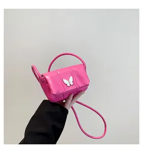 Detail of a hot pink mini handbag with a white butterfly accent and quilted texture