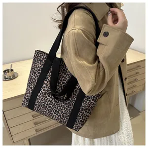 Modieuze luipaardprint tote bag getoond op model met zwarte canvas riemen voor werk