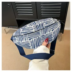 Close-up of woven canvas chest bag showing blue and white geometric patterns and zipper