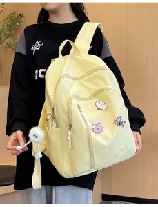 Sac à dos en nylon imperméable jaune clair avec badges de dessin animé et pendentif peluche