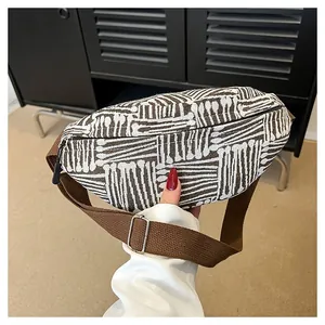 Detail of canvas chest bag featuring brown geometric patterns and adjustable strap
