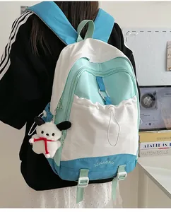 Detail eines farblich abgesetzten Schulrucksacks mit Kordelzugtasche und Plüschanhänger