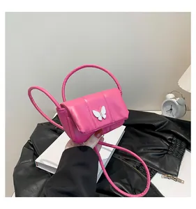 Detail of rose pink puffy mini crossbody bag with white butterfly clasp and long strap