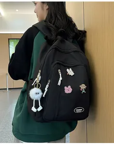Sac à dos noir en nylon avec badges de dessins animés et charm boule en peluche blanche