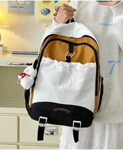 Detail eines dreifarbigen Patchwork-Rucksacks mit Kordelzugtasche und Plüschtier-Anhänger