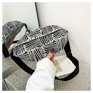 Detailed close-up of woven canvas chest bag with geometric black and white patterns