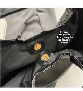 Nahaufnahme der schwarzen Ledertasche mit goldener Magnetschnalle für einfaches Schließen
