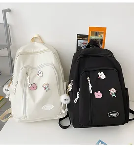 Détails de sacs à dos minimalistes en nylon avec badges de dessins animés et pompons