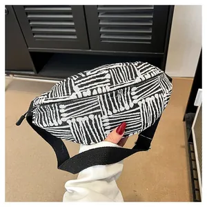 Detail view of woven canvas chest bag with black and white stripes and adjustable strap