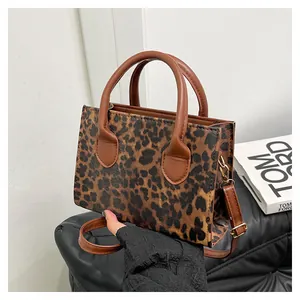 Detail of leopard print faux leather bag with round handles and detachable strap D-ring