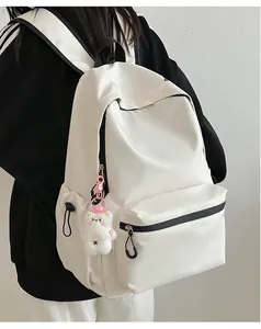 Achteraanzicht van een witte minimalistische nylon rugzak met berenhanger voor dames