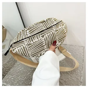 Detail of canvas chest bag with olive green geometric stripes and adjustable strap