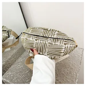 Detailed shot of green and white geometric striped canvas chest bag with adjustable strap