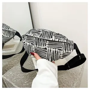 Detail of canvas chest bag featuring bold black and white geometric stripe patterns