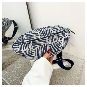 Detailed close-up of blue and white striped canvas texture on stylish crossbody bag