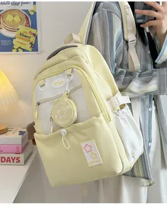 Detailansicht des cremegelben Rucksacks mit vielen Taschen und kleinem Dekotäschchen