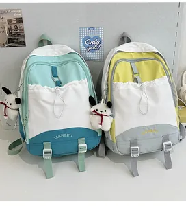 Detail von farbblockierten Schulrucksäcken mit Kordelzugtaschen und Plüschanhängern