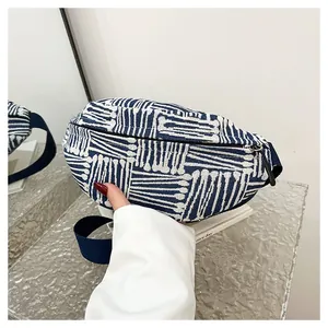 Detail of blue and white striped canvas chest bag with adjustable navy strap