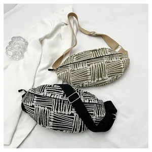 Close-up of woven canvas chest bags with ethnic geometric patterns and adjustable straps