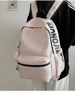 Detailopname van roze rugzak met zwarte letters en een witte pluche tas-hanger