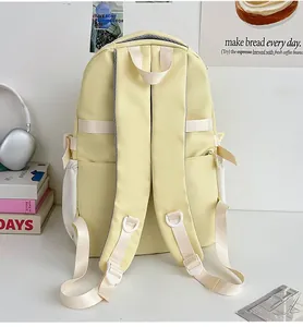 Detail eines hellgelben Schulrucksacks mit breiten Schultergurten und Reflexionsstreifen