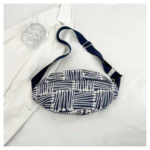 Flat lay of canvas chest bag with blue and beige geometric stripes and adjustable strap