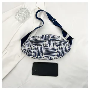 Detail of blue and white geometric canvas chest bag with adjustable strap and phone