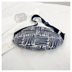Detail of blue and white geometric canvas chest bag with adjustable woven strap