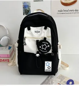 Detail eines schwarz-weißen Rucksacks mit Stern-Anhänger und vorderem Reißverschluss