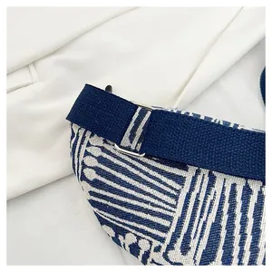 Detailed close-up of geometric jacquard fabric and silver metal hardware on a chest bag