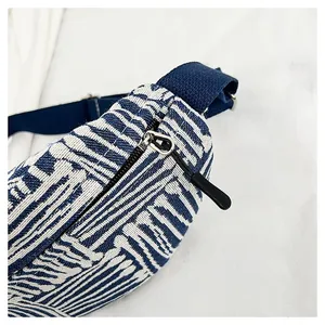 Detail of blue and white striped canvas waist bag showing zipper and woven texture