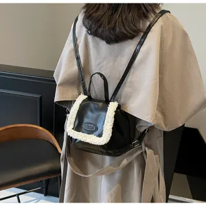 Detailed view of mini black leather backpack with fuzzy white faux fur trim and adjustable straps