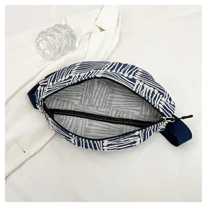 Detail view showing large interior capacity of blue striped canvas crossbody bag