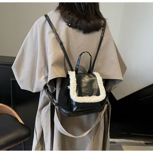 Mini black leather backpack with white shearling trim and FASHION patch worn by model