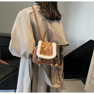 Detalle de la mochila de cuero sintético marrón con ribete de piel sintética y un cascabel